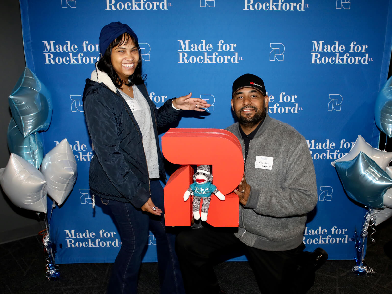 Rockford residents posing with the GoRockford logo and a sock monkey
