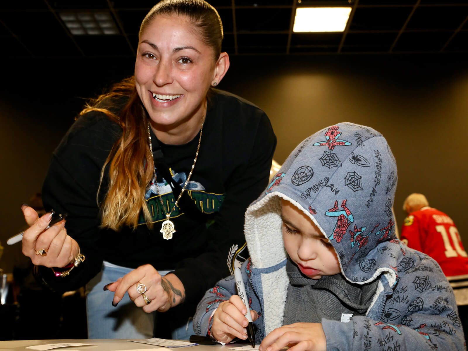 A mother and son filling out name tags at Made for Rockford's mixer