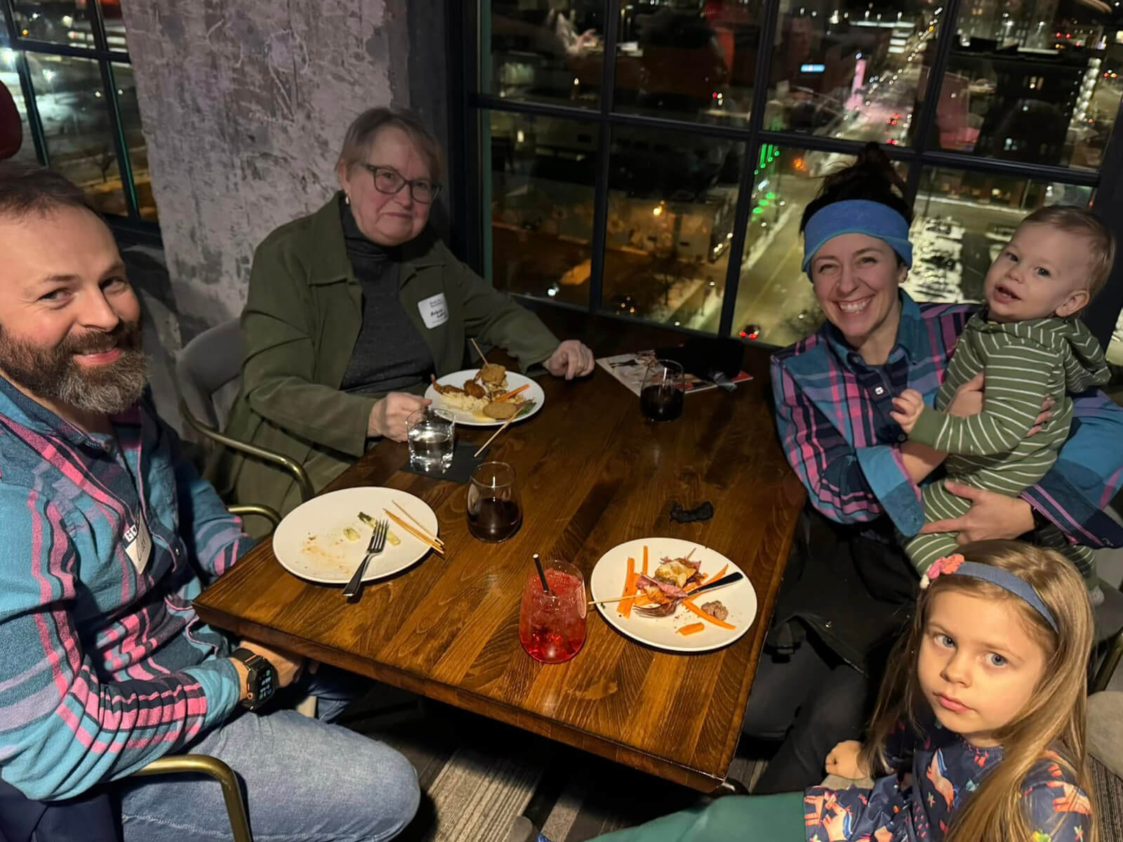 A family sitting at a table eating food at a Rockford new resident mixer