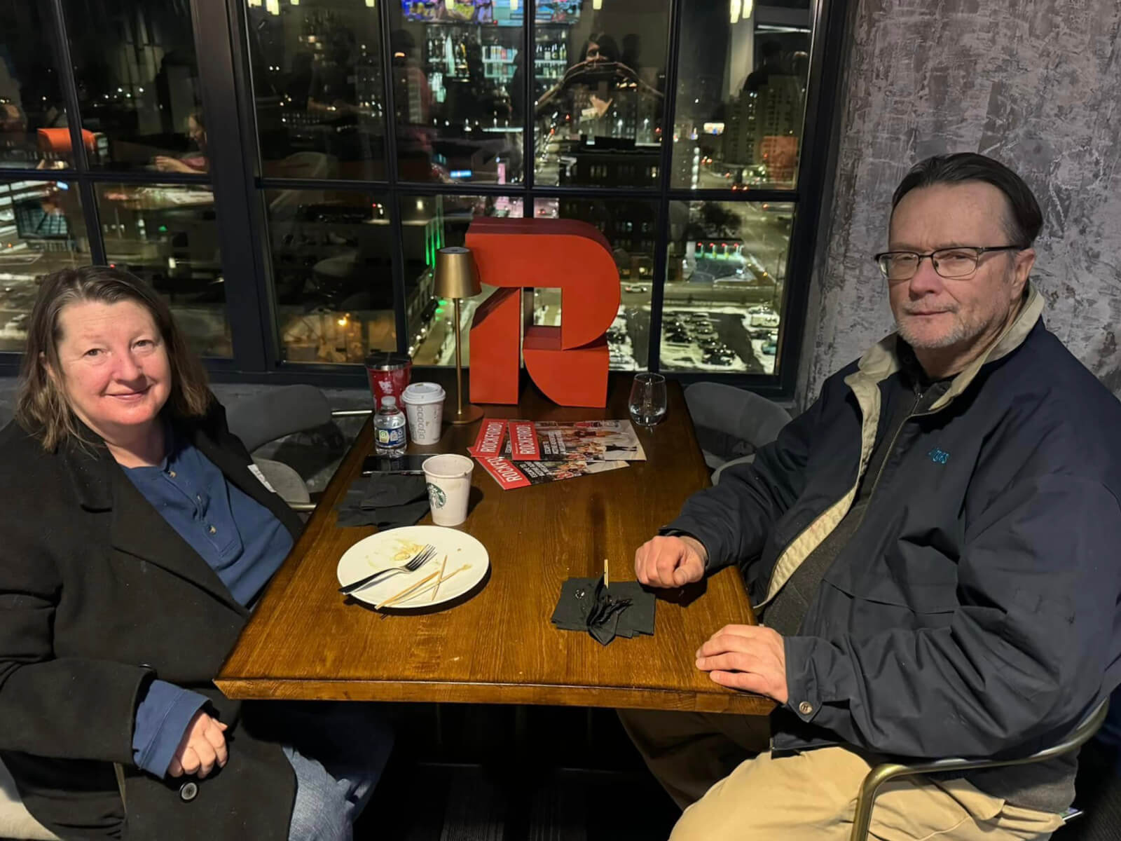 A couple sits at a table with the GoRockford logo