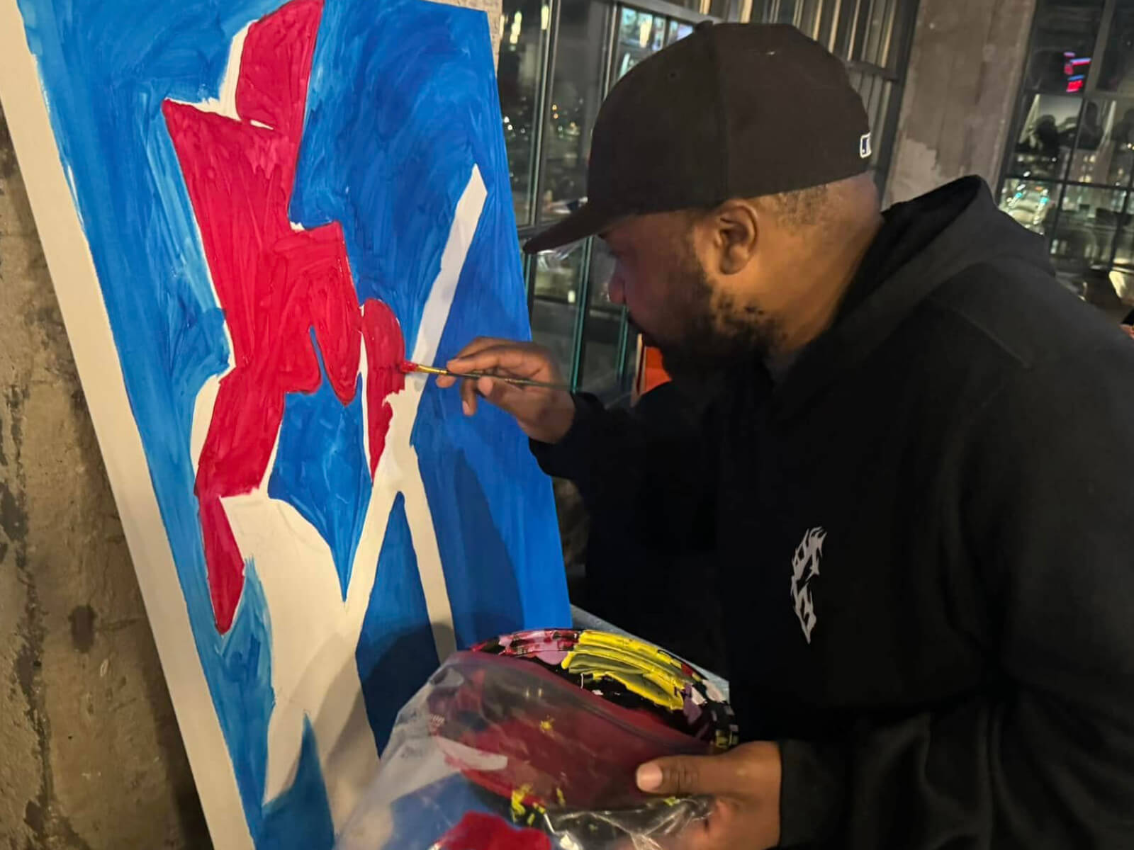 A man painting the Rockford Symbol Sculpture on a canvas