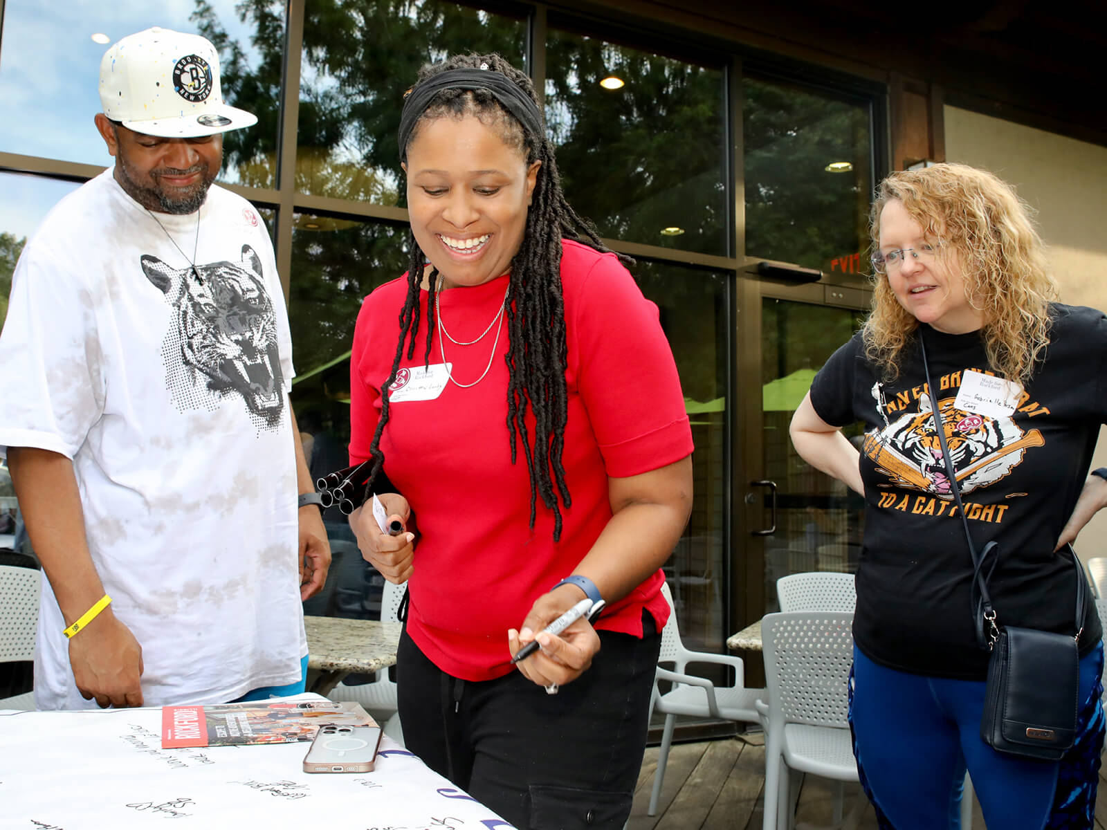 Rockford residents sign a table cloth at a new resident mixer