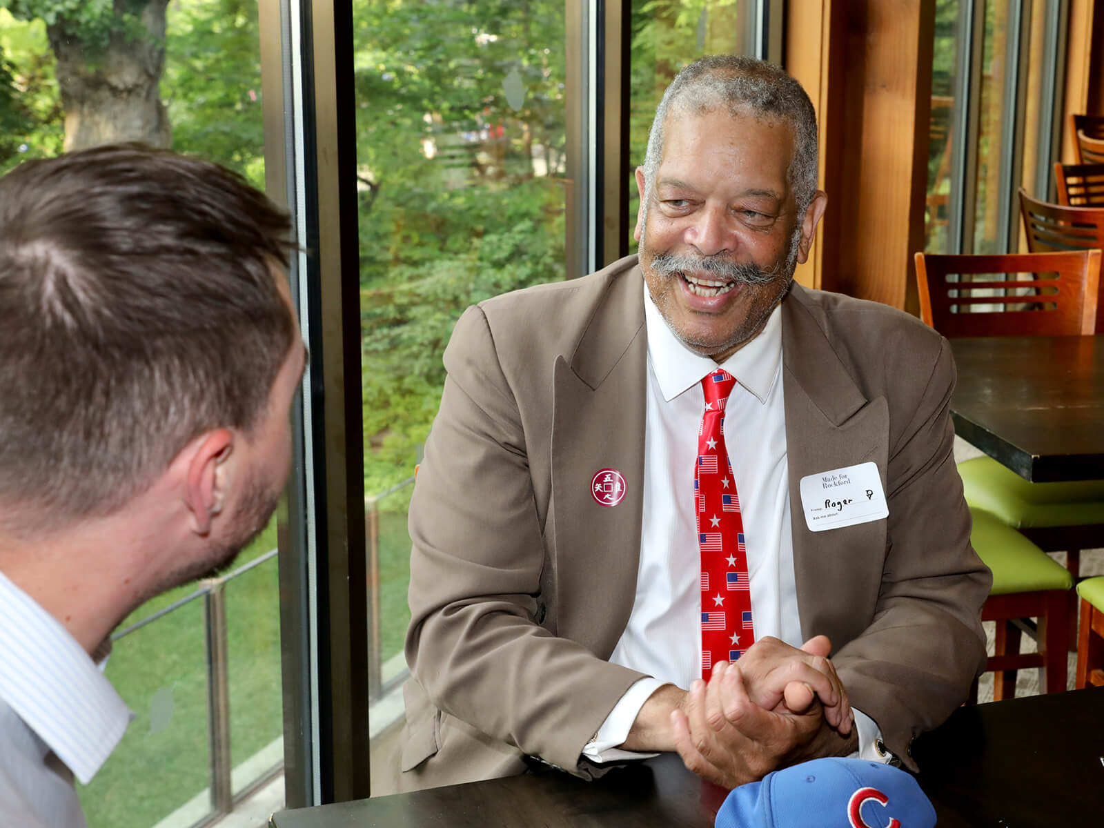 Two Rockford residents chat at a table at Anderson Japanese Gardens for a new resident mixer