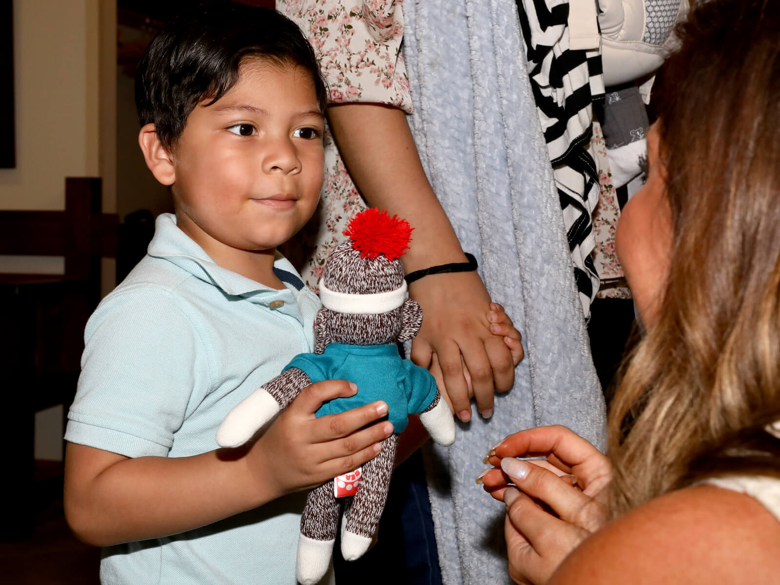 A boy holding a sock monkey at a Made for Rockford new resident mixer