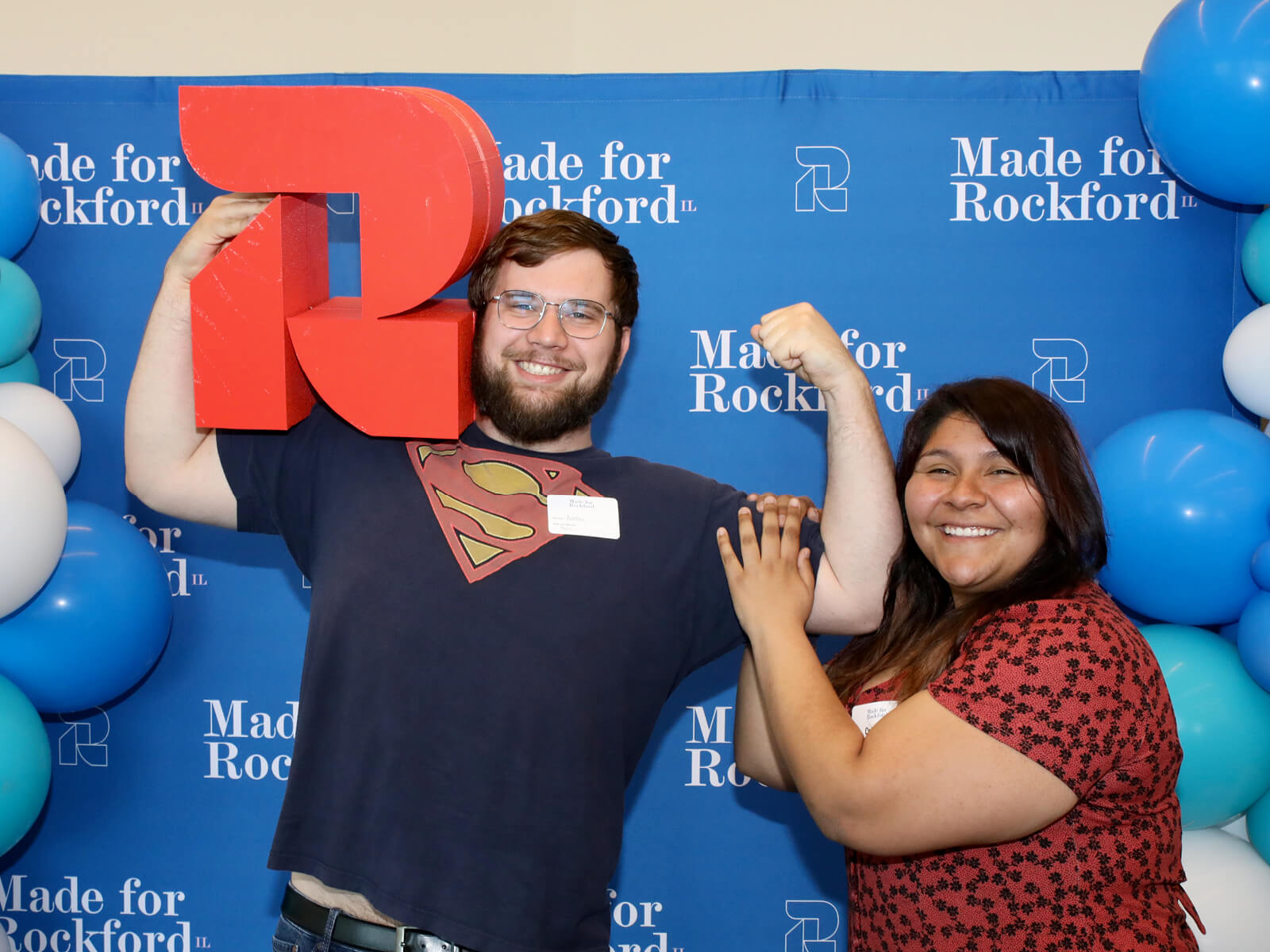 A couple posing with the GoRockford logo at a new resident mixer