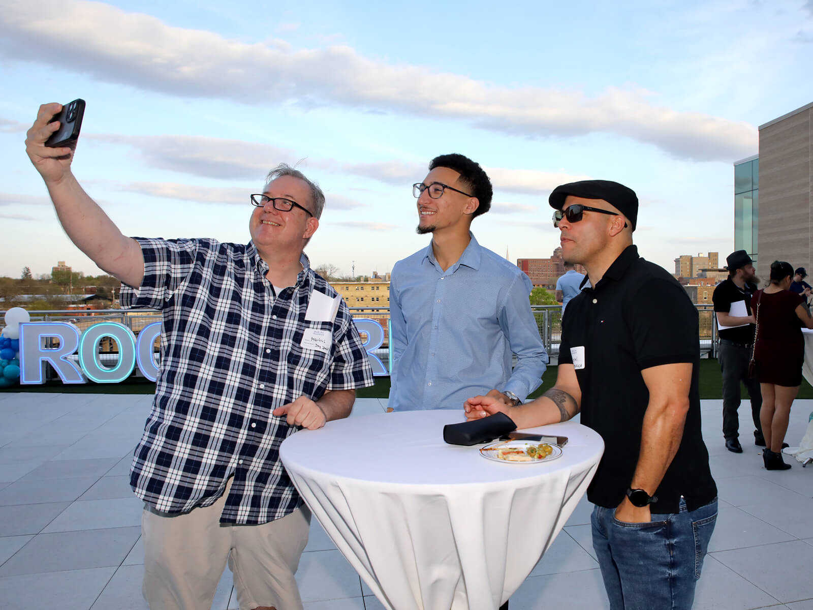 Three men take a selfie at a Rockford new resident mixer