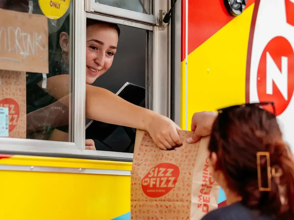 Woman handing food out of the window of a food truck